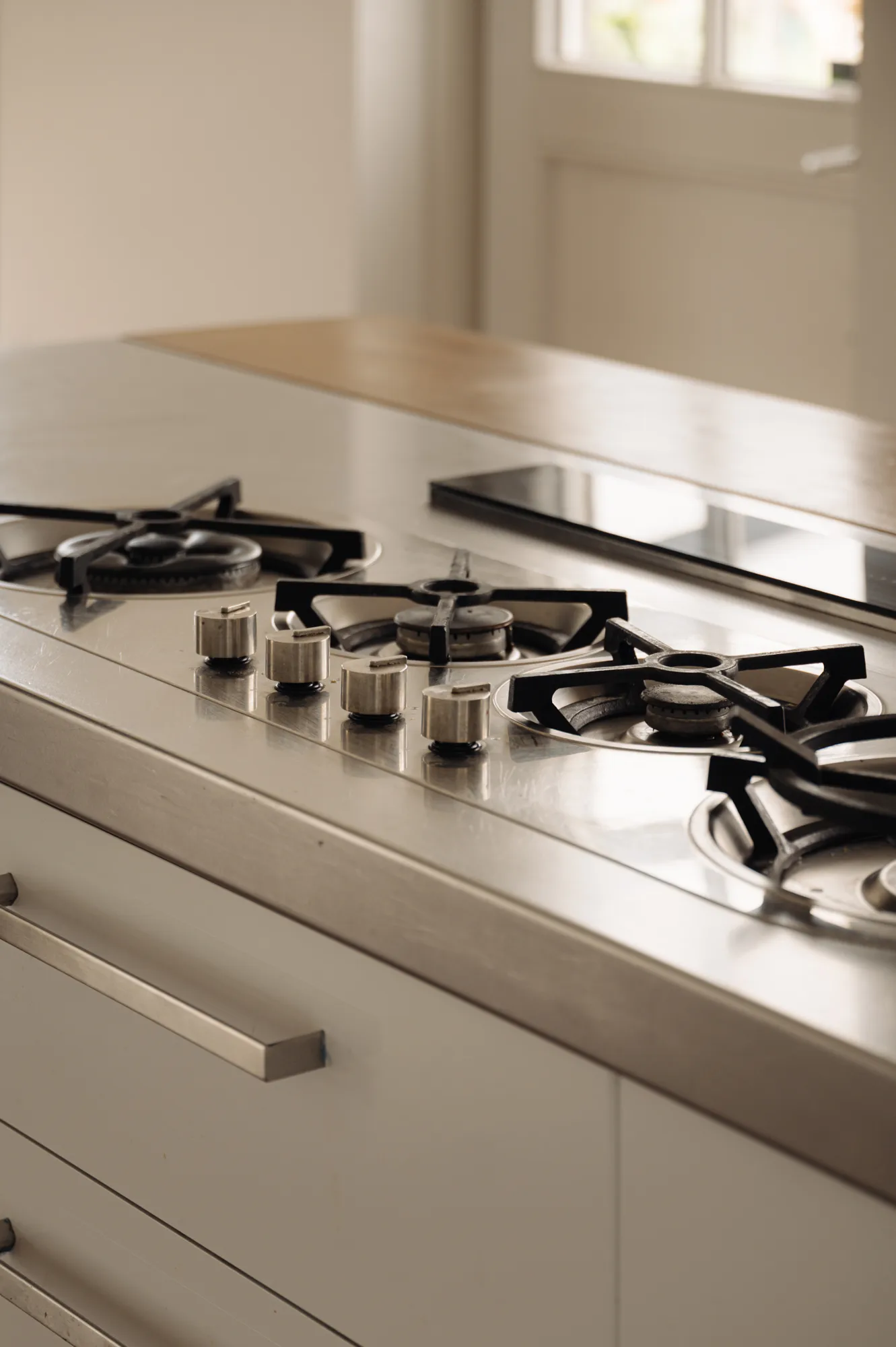 Gas cooktop set into a stainless steel island counter